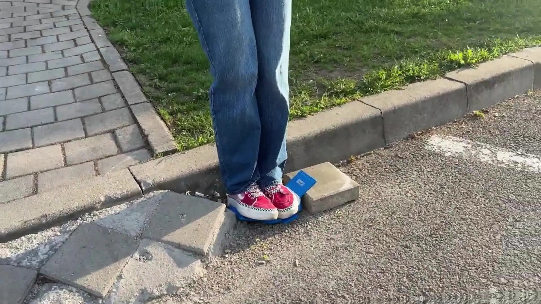 A Renault tire rolls over a blue magnetic embroidery hoop on asphalt during an extreme durability test.