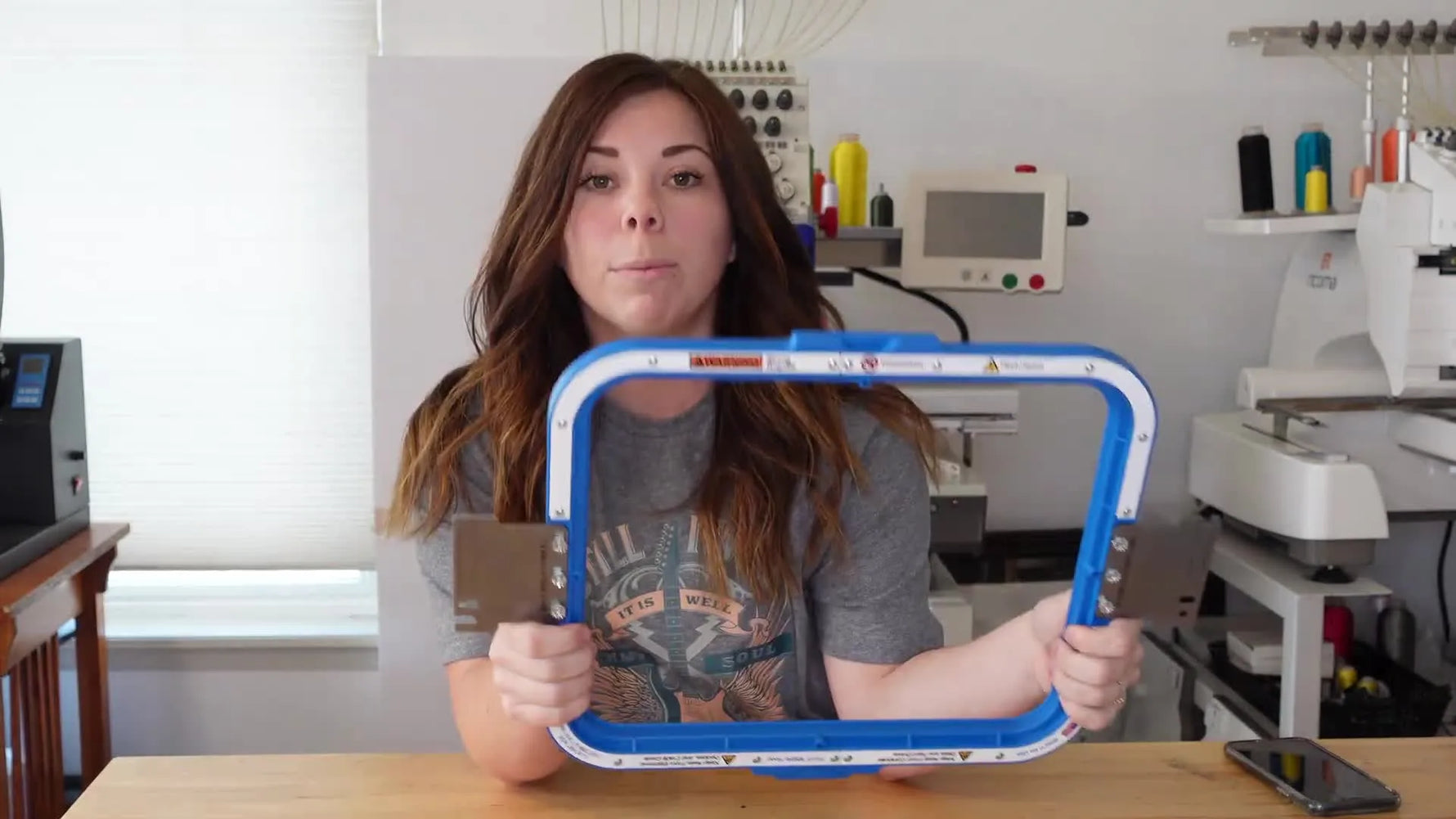 Woman holding up a Mighty Hoop for an embroidery machine.