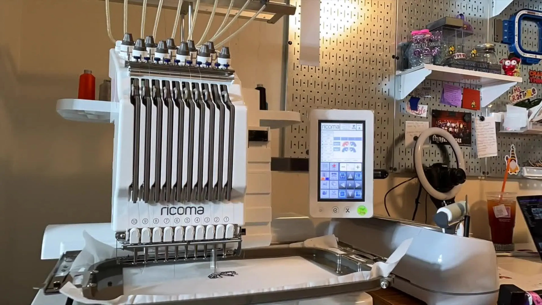 A close-up of the Ricoma EM1010 actively stitching an orange-and-black snake logo patch at speed.