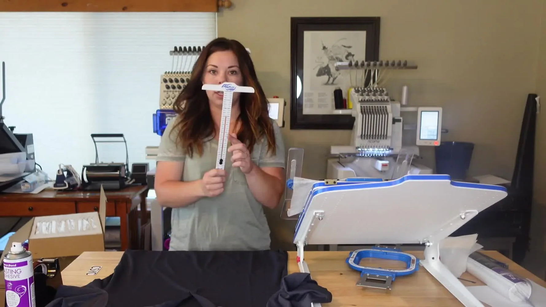 Kayla using a T-square to align embroidery design on a polo shirt.