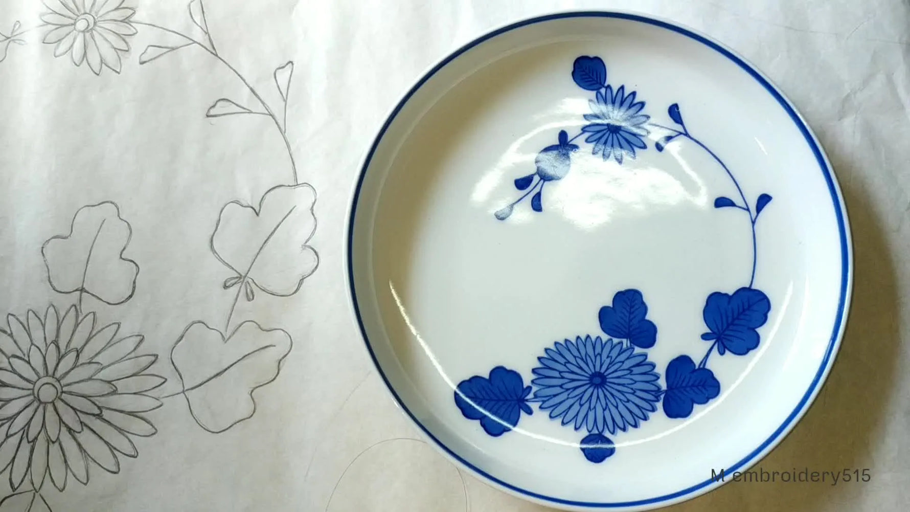 Ceramic plate with blue floral design next to fabric with a matching outline.