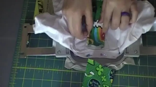 A pinned child’s T-shirt is positioned on the embroidery machine using placement stitches, ready for the 3D tie to be attached.