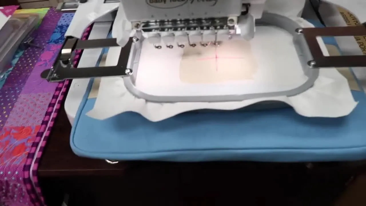 A close-up of a standard hoop with a rectangular window cut out of peel-and-stick stabilizer, exposing the fabric underneath for clean stitching on thick items.