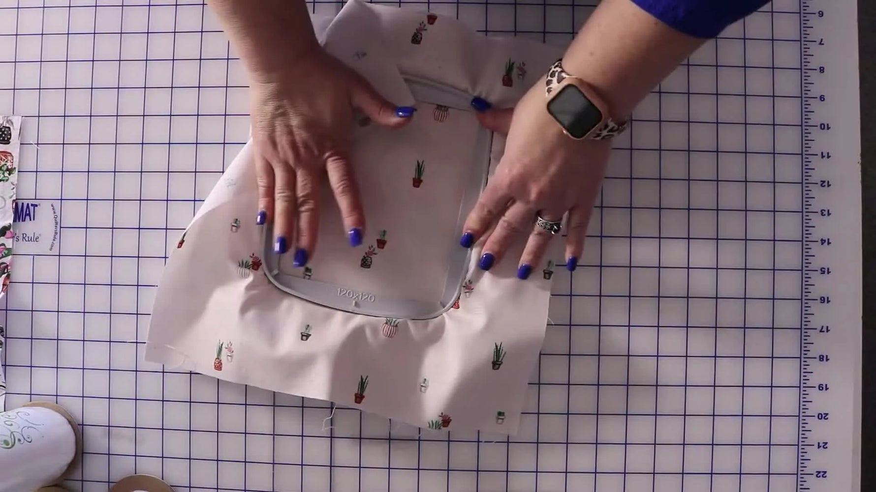 Hands press the inner hoop into the outer hoop to sandwich fabric and stabilizer for a firm, even hooping.