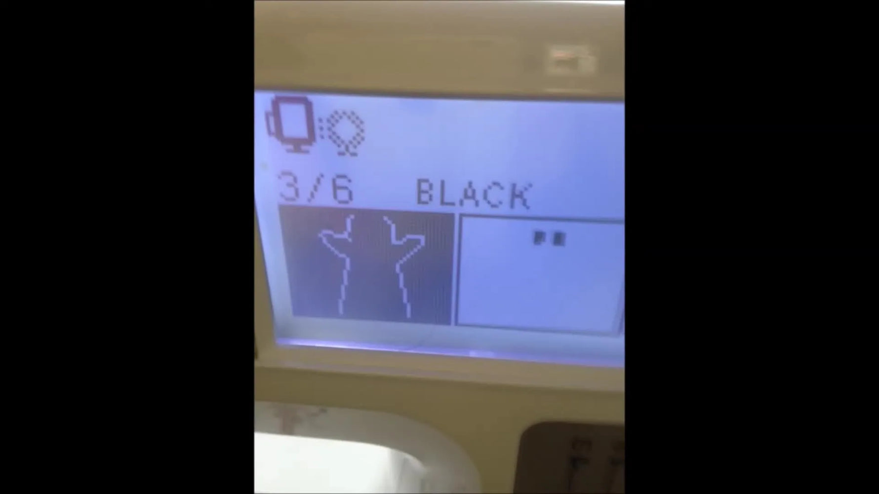 A finished in-the-hoop felt finger puppet is held up by hand, showing the bean-stitch border and the open bottom pocket.