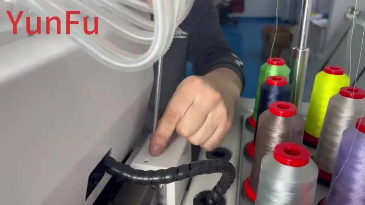 A close-up of white grease being brushed onto the internal gears inside a multi-needle embroidery machine head.