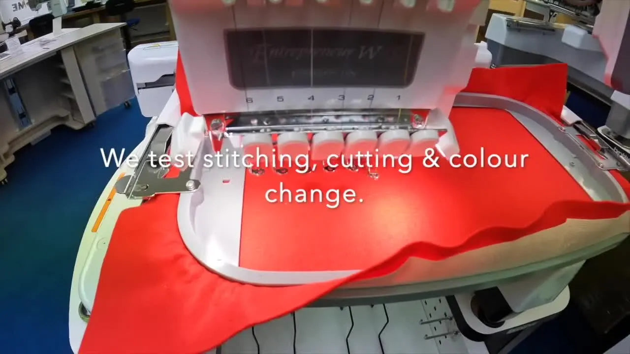 A close-up view of the Brother PR680W needle bar stitching into hooped red fabric during a pre-delivery test run.