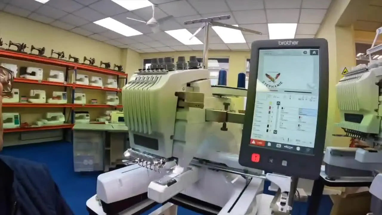 A Brother PR680W sits on its stand with red fabric hooped and ready for a controlled pre-delivery test stitchout.