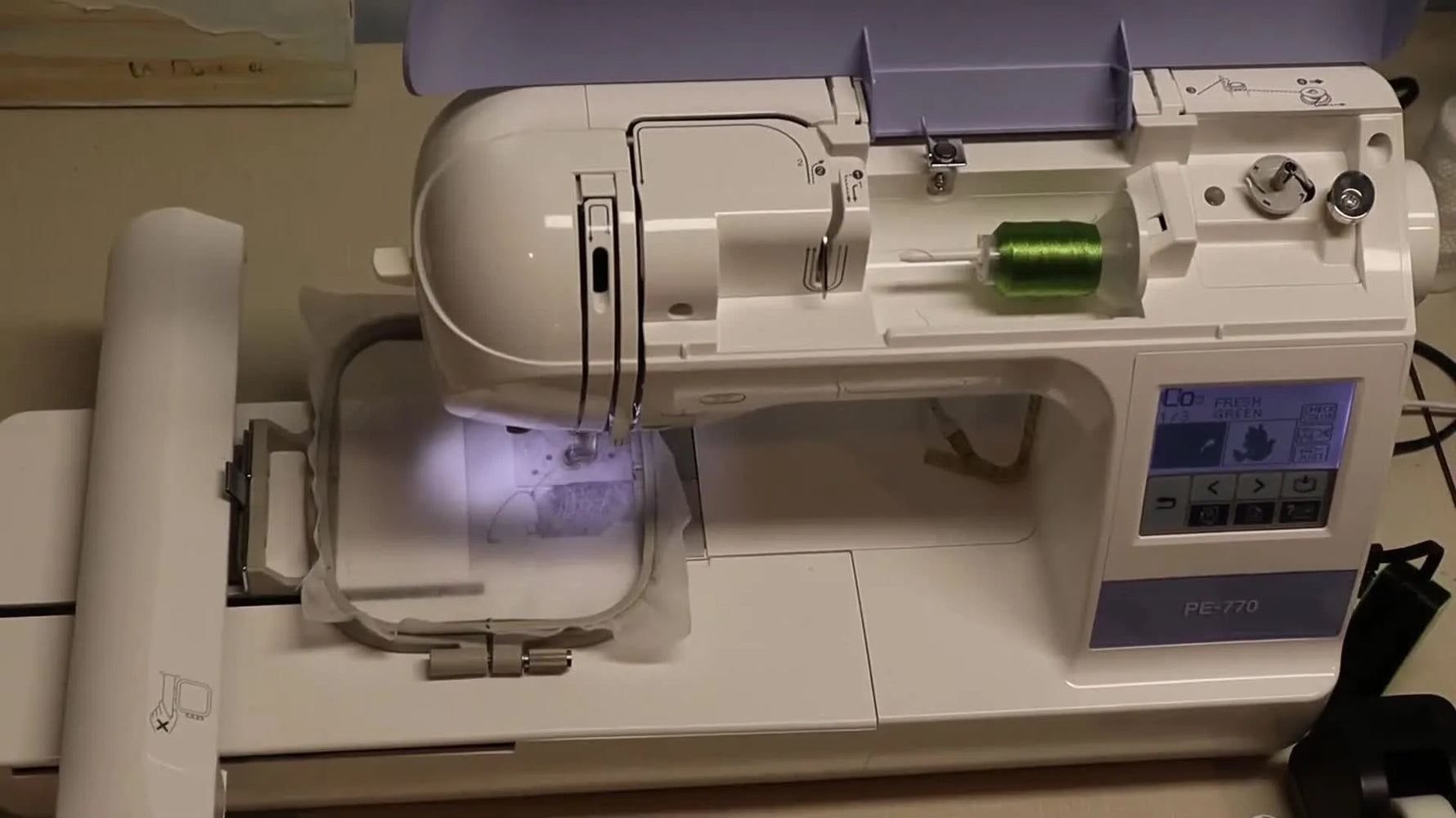 A close-up of the Brother PE770 actively stitching the green leaf section of a free-standing lace dove ornament on water-soluble stabilizer.