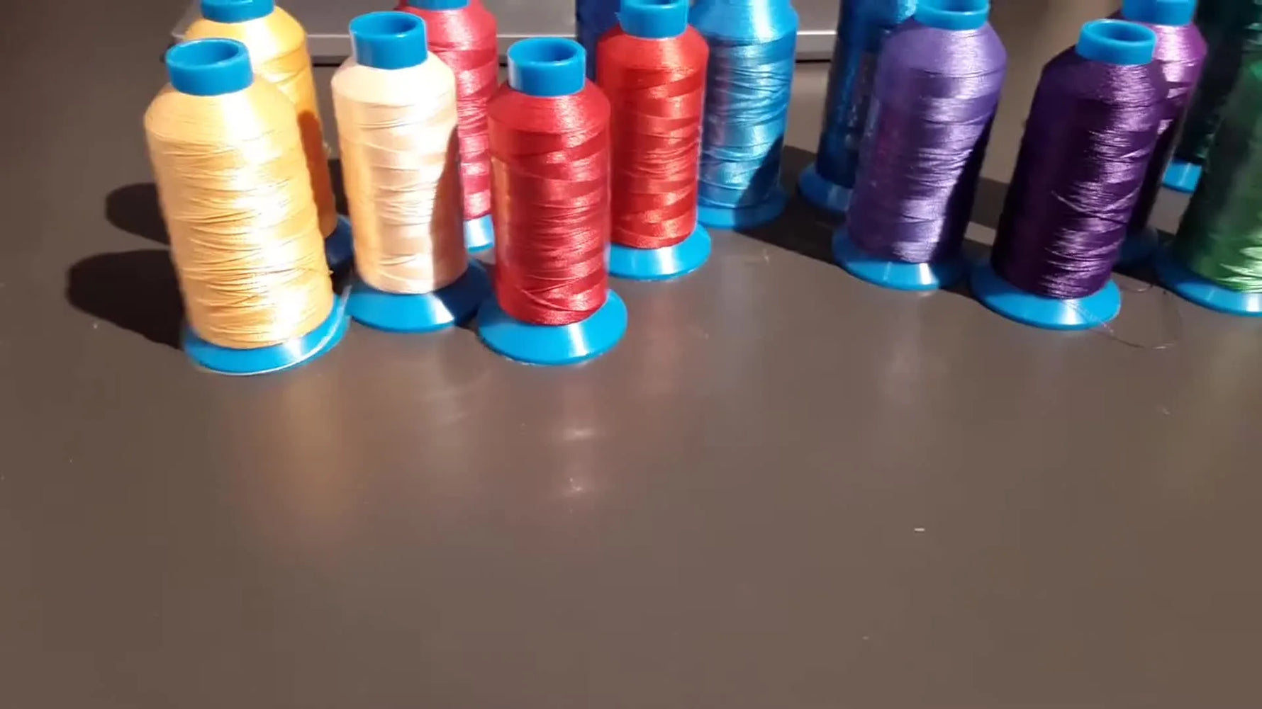 A wide spread of colorful embroidery thread spools laid out for choosing brands, building shading sets, and organizing storage.