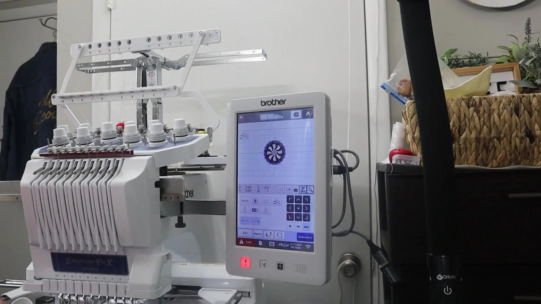 A finished peppermint candy coaster is held up in the hoop, showing a crisp white lace rim and a bold red stitched center.