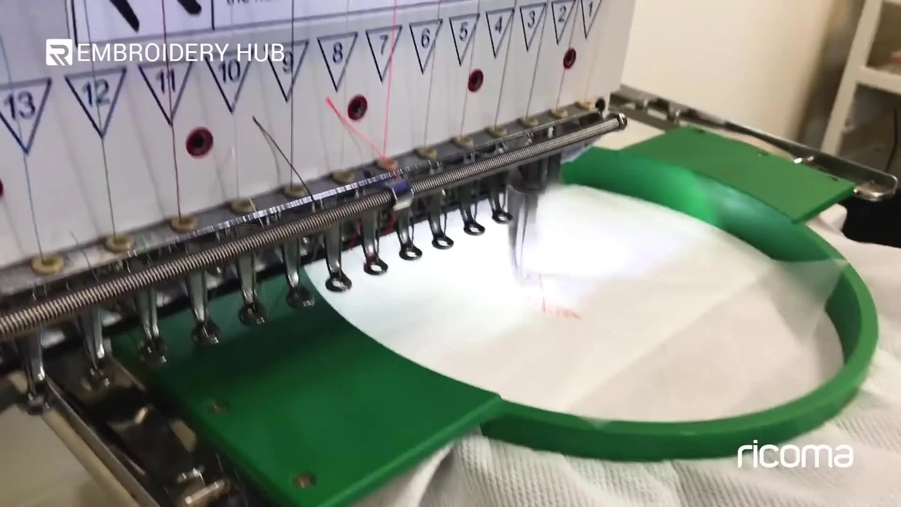 A close-up shows a commercial embroidery machine stitching a pumpkin design onto toilet paper at a controlled speed.