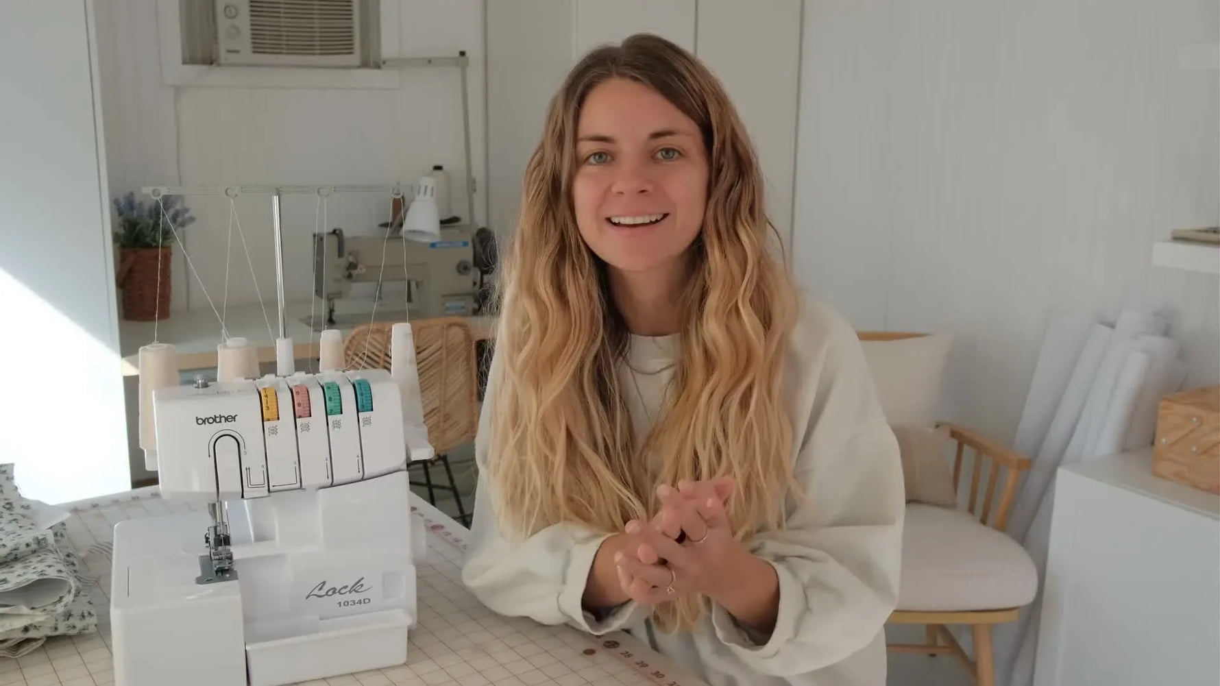 Woman demonstrating sewing with a Brother 1034D serger machine.