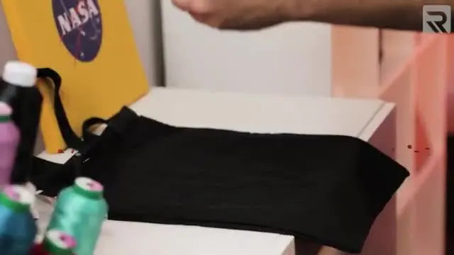 A close-up of the top magnetic frame snapping down onto a canvas tote bag, showing the fast, even clamp that makes thick items easy to hoop.