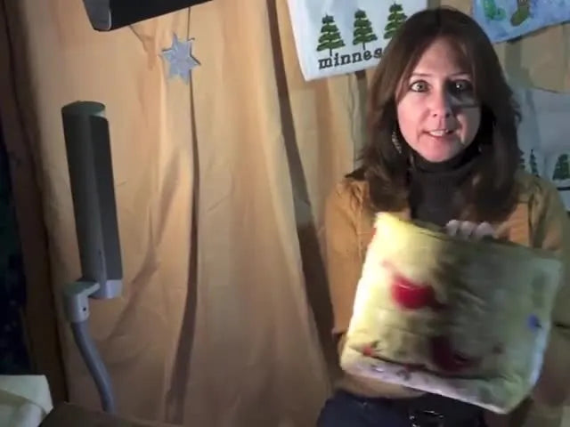 A finished Christmas-themed freestanding fabric box is held up to show its crisp shape and sharp corners.