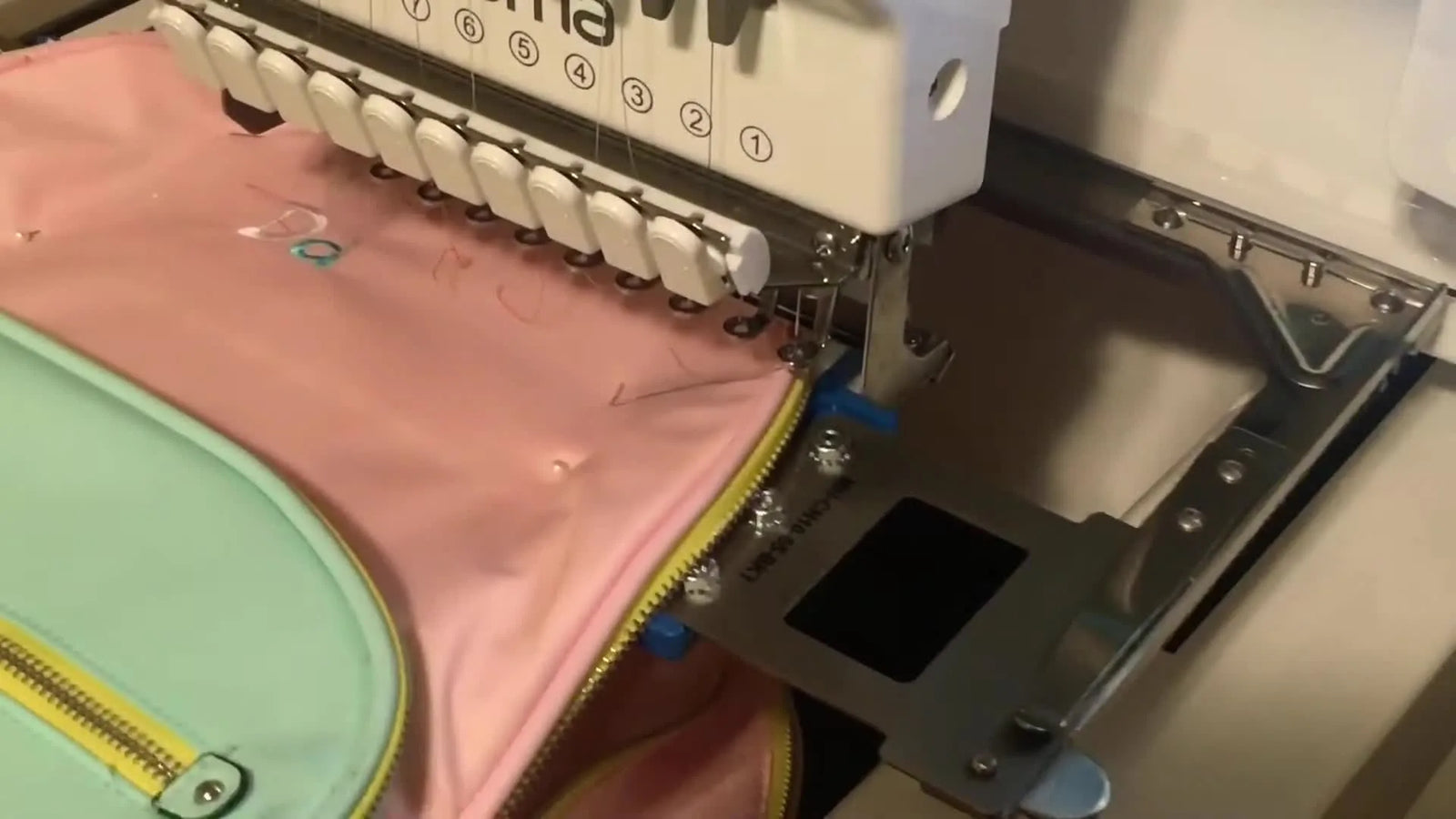 Monogram na plecaku na Ricoma EM1010: metoda z tamborkiem magnetycznym, która zatrzymuje ślizgający się nylon (i ratuje nerwy)