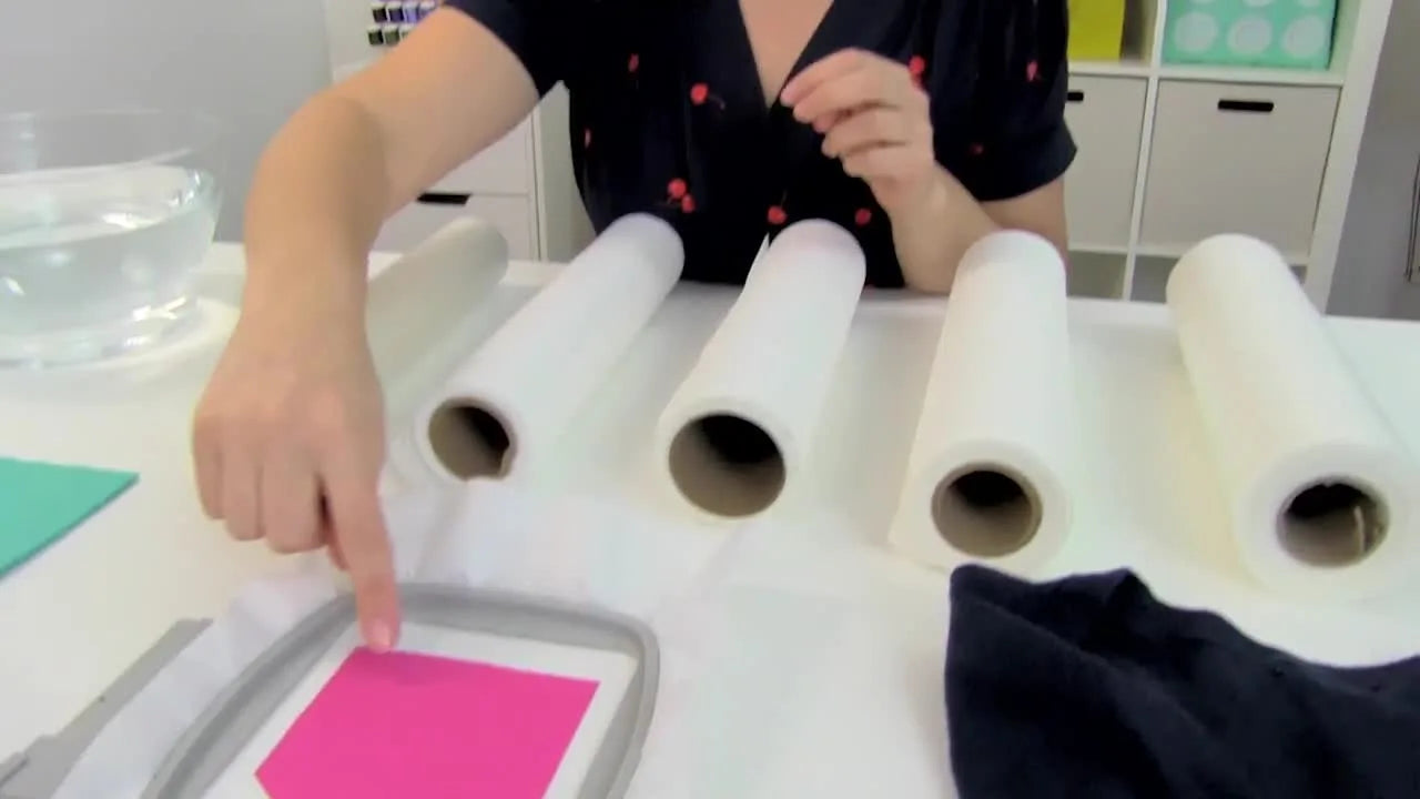 A small pocket is pressed onto hooped sticky stabilizer, demonstrating the floating technique for items too small to hoop normally.