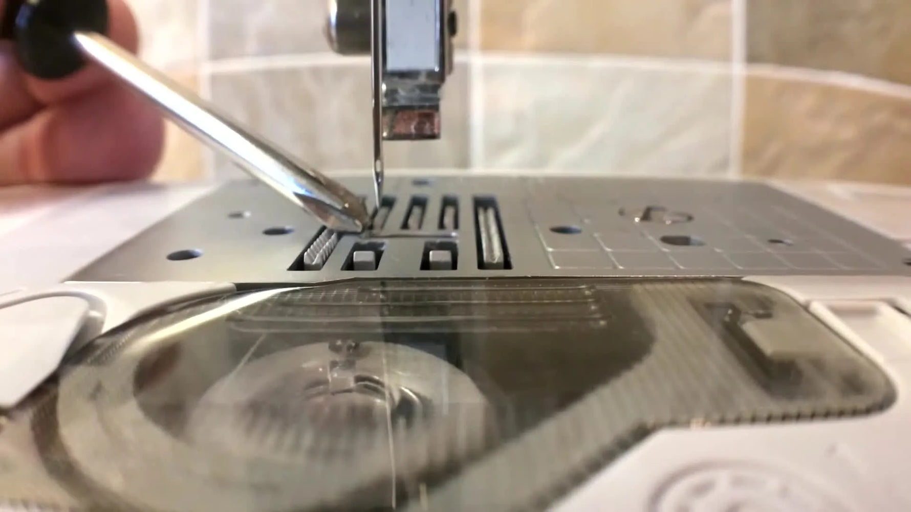 A macro view shows the Brother Innov-is 950 needle tip sitting off the throat-plate groove, the key visual cue used to calibrate needle centering.