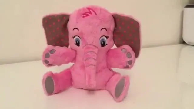 A finished pink ITH plush elephant sits upright on a white table, showing clean facial embroidery and neatly attached limbs.