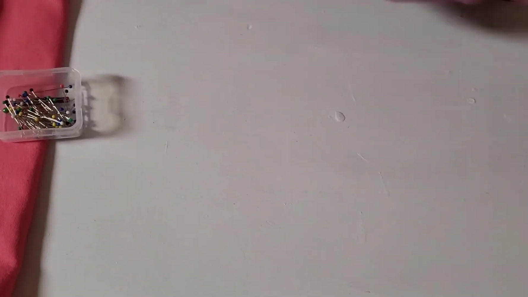 A finished faux chenille “M” patch in the hoop with a gold glitter HTV border and a white towel interior, ready to be cut out and heat pressed.