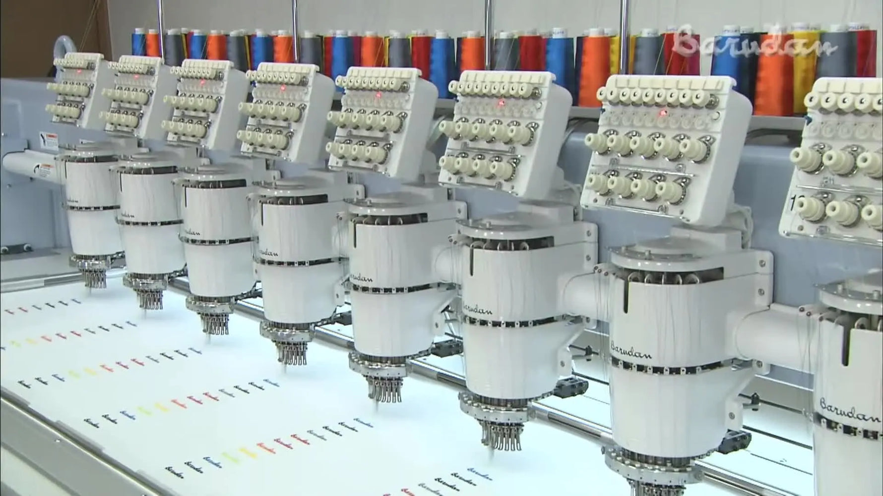 A wide-angle view of multiple Barudan multi-head machines running simultaneously in a production environment.