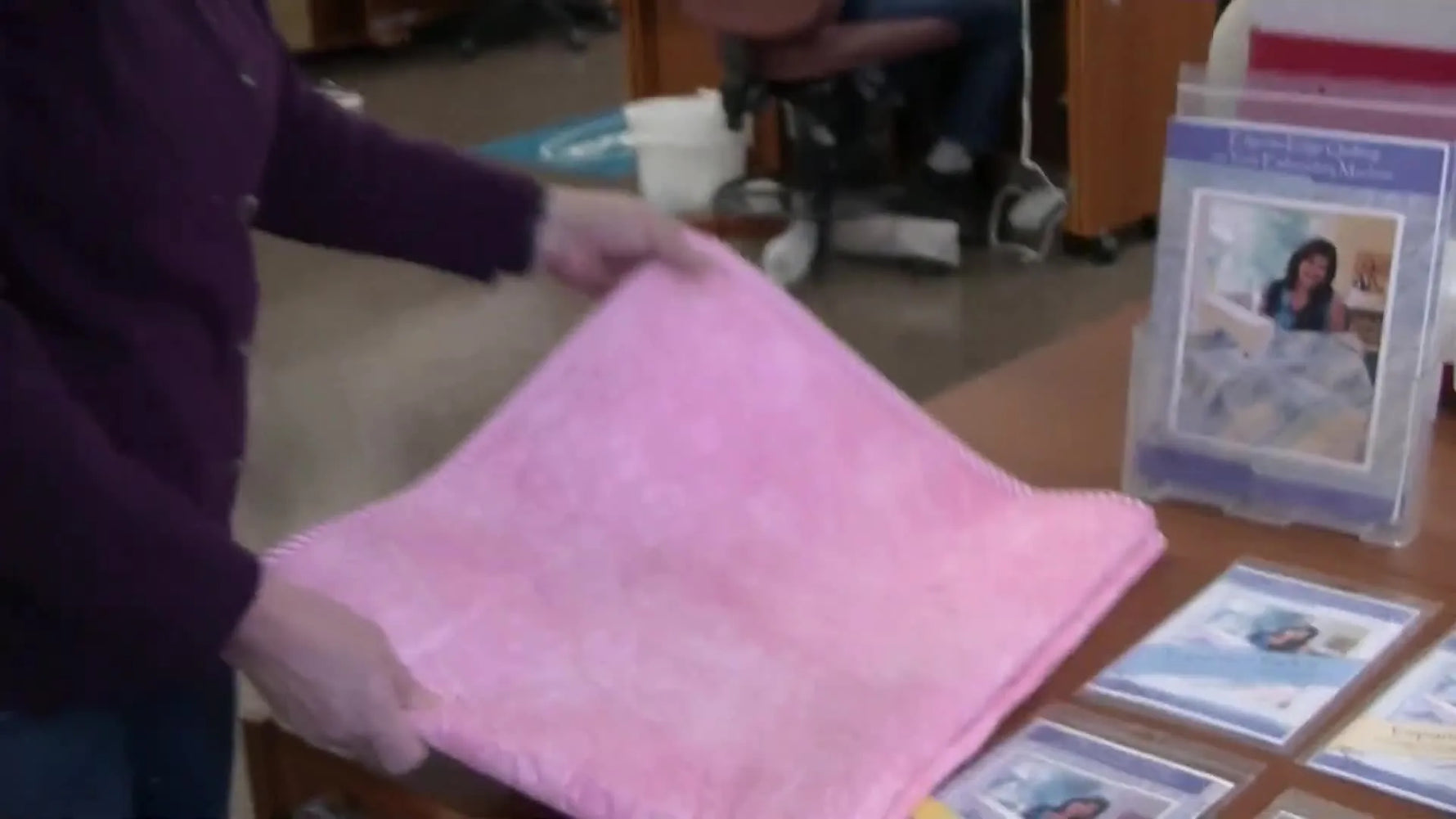 A finished pink quilt shows a continuous edge-to-edge floral quilting pattern stitched in connected hoopings for a longarm-style look.