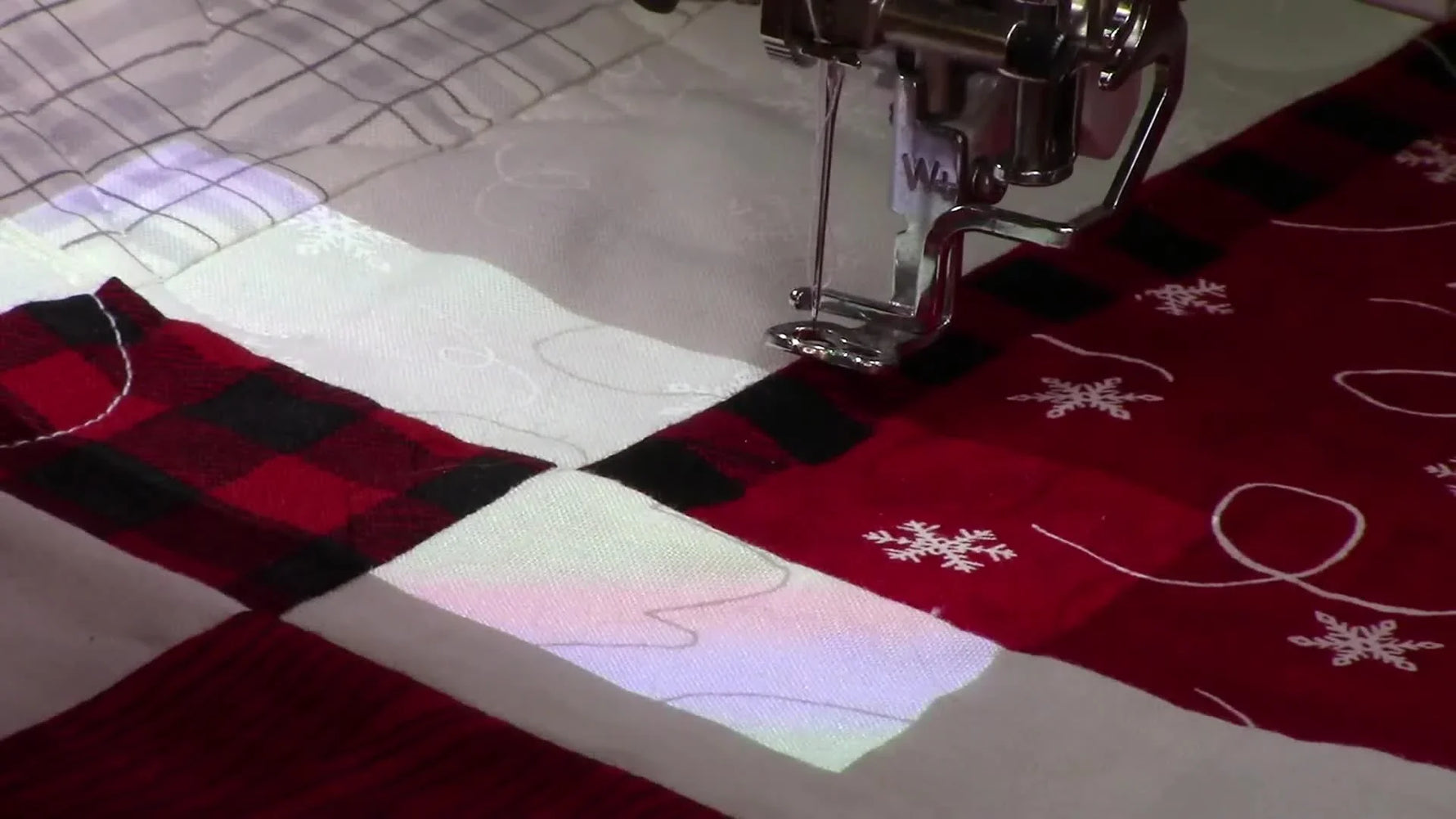 The Brother Luminaire projector casts quilting design lines onto the quilt surface so you can align an end-to-end connection point before securing the magnetic sash frame.