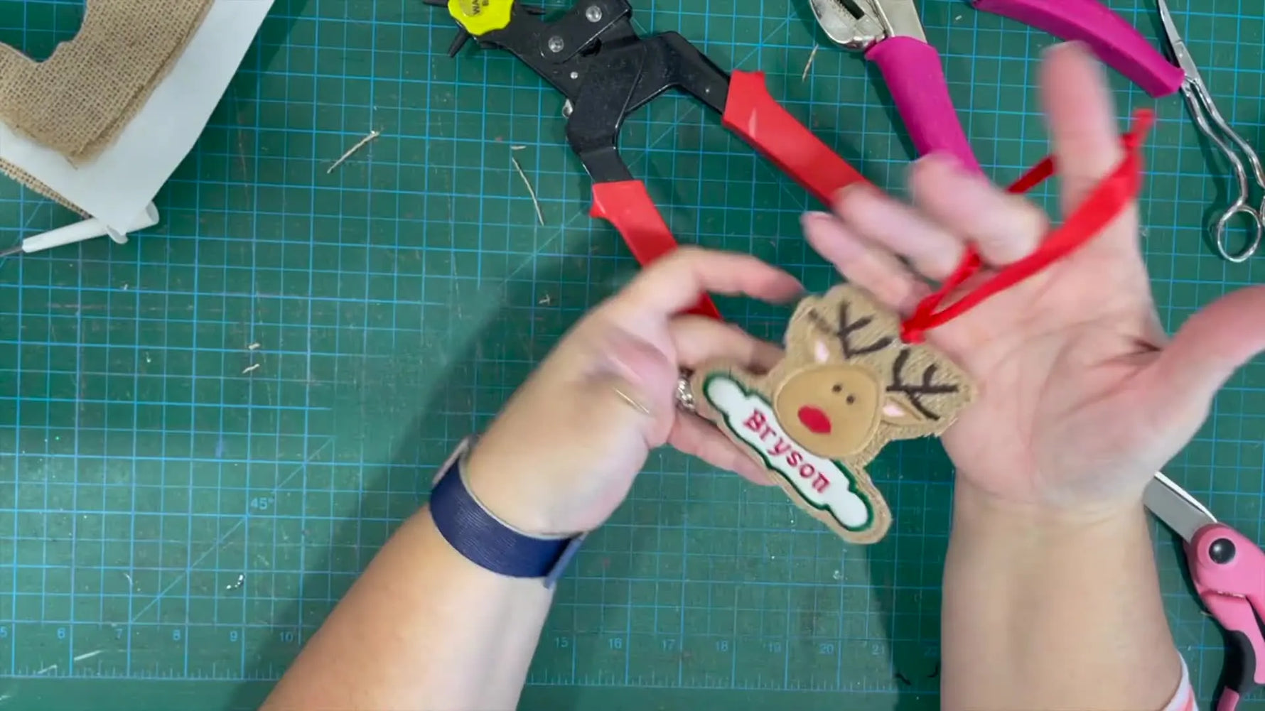 The finished ITH reindeer ornament is shown with a ribbon hanger, ready to display.