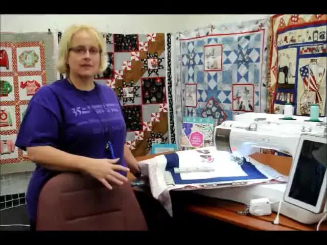 Woman standing next to a sewing machine, demonstrating.