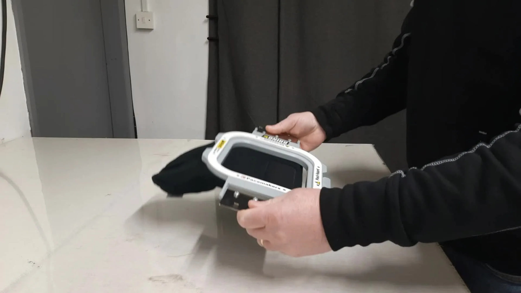 An overhead view of a square magnetic hoop snapped onto an inverted beanie, framing the twill patch flat and centered for embroidery.