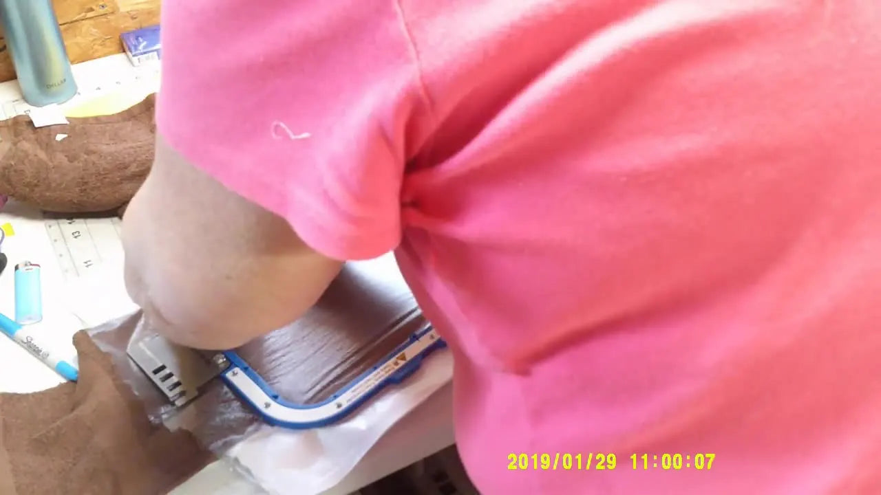 An overhead close-up of a thick towel hooped in a 10x10 magnetic frame with water-soluble topping, ready for applique embroidery.