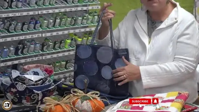 Close-up of a recycled denim tote bag featuring circular patches and free-motion quilting details.