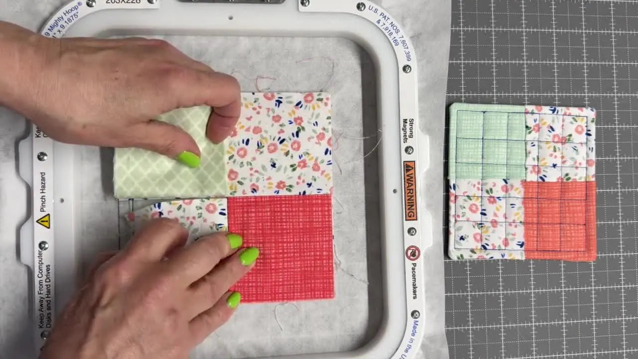 Overhead close-up of the woven placement technique, lifting the first fabric flap to slide the final square underneath for a clean pinwheel look.