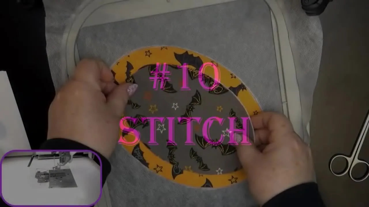 Hands place a pre-cut bat-print applique piece onto hooped stabilizer attached to the embroidery machine, right before stitching begins.