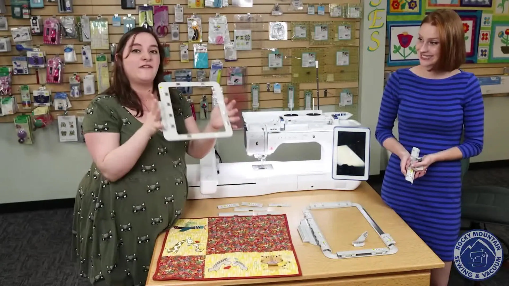 A host holds the Brother 5x7 Magnetic Sashing Frame up to the camera so the size and shape are clearly visible.
