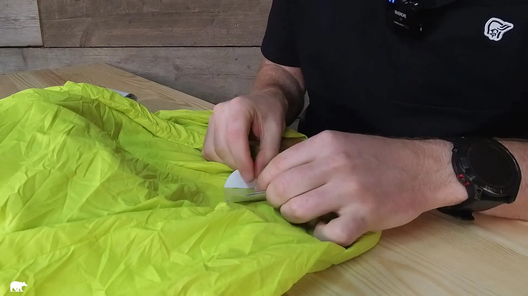 Hands applying the patch to the yellow windshell from the middle.