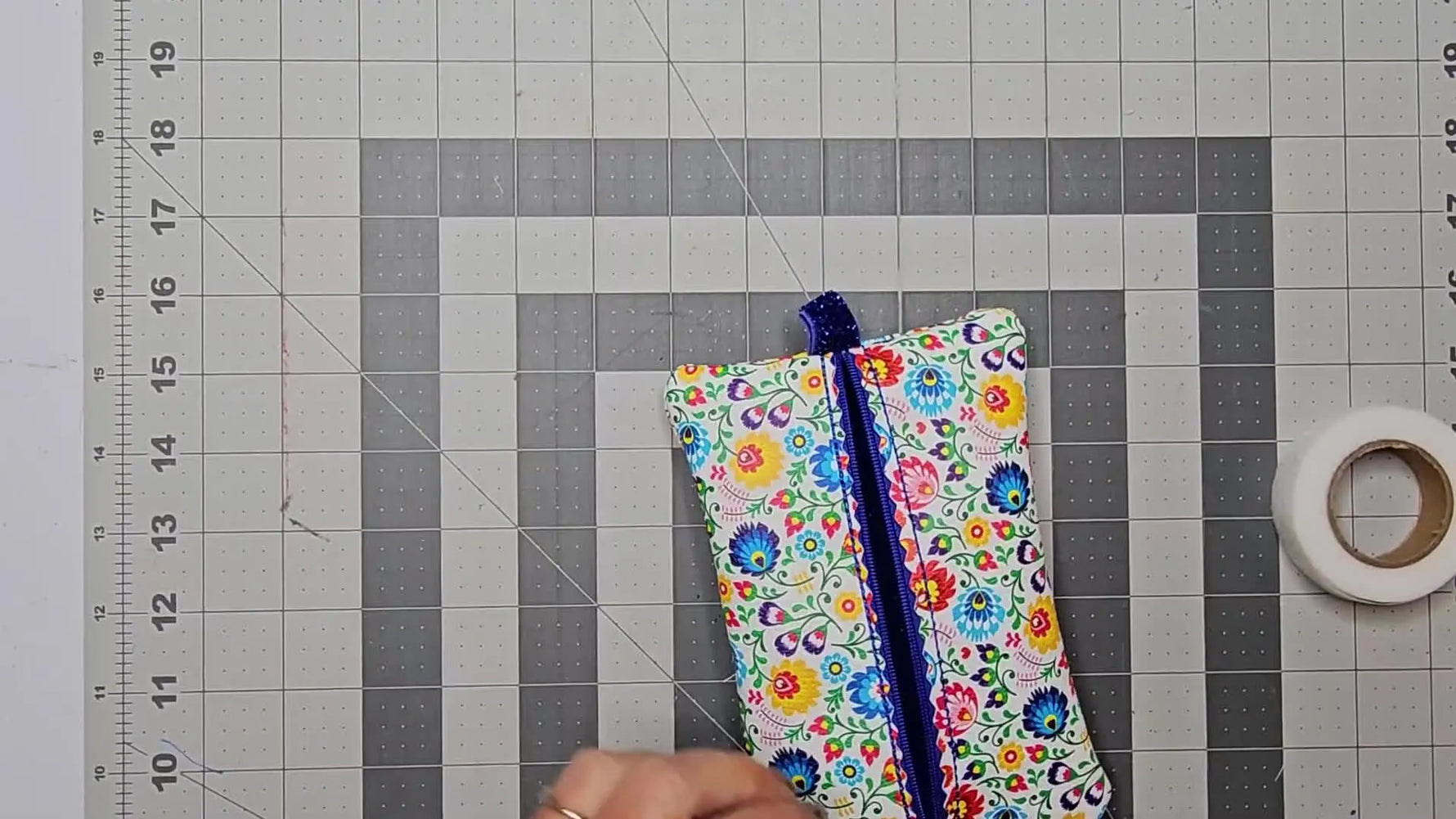 A finished floral center zip bag with a neat zipper and fully lined interior displayed flat on a cutting mat.