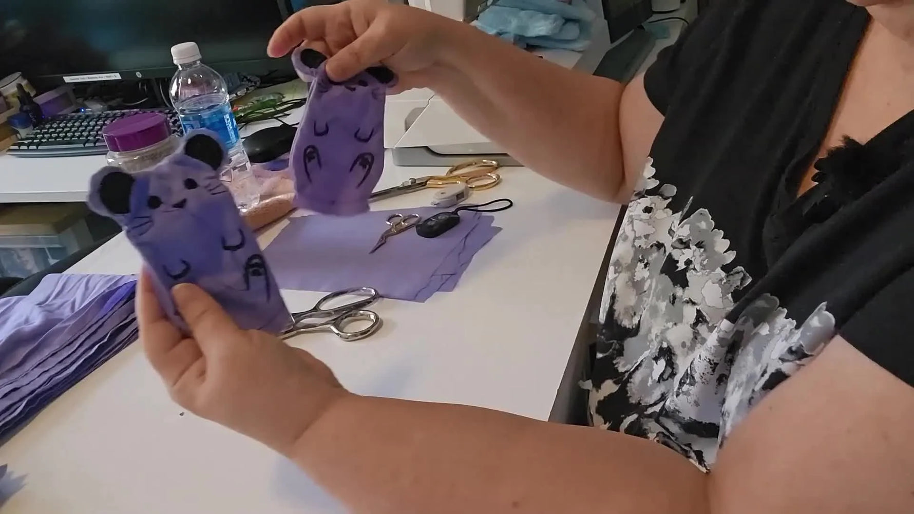 The finished (un-stuffed) ITH mouse shell is held up close, showing crisp facial details and clean seam shaping.
