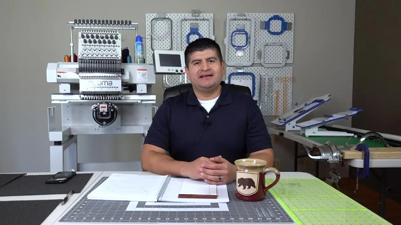 A shop owner sits at a desk with a Ricoma MT-1501 visible behind him and hoops displayed on the wall, setting the tone for a practical, real-owner review.
