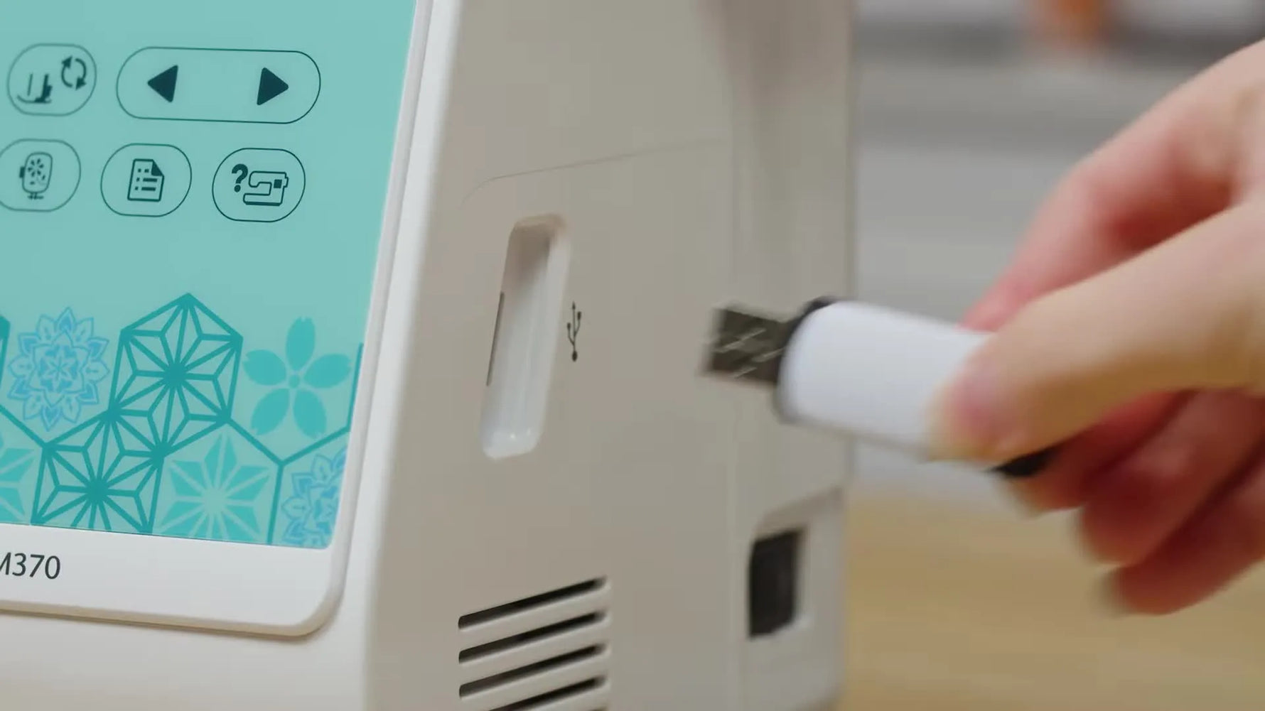 A close-up shows a hand inserting a white USB drive into the Brother Innov-is M370’s side USB port.