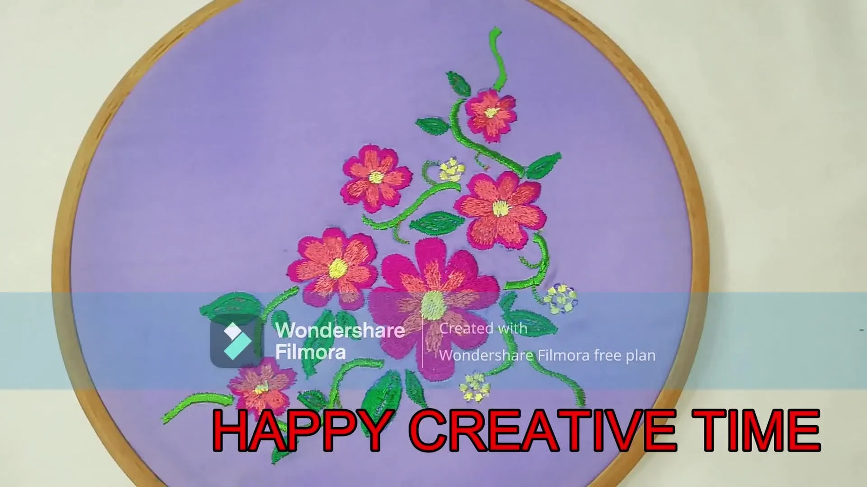 The finished floral bouquet embroidery is shown neatly stitched on purple fabric inside a wooden hoop.