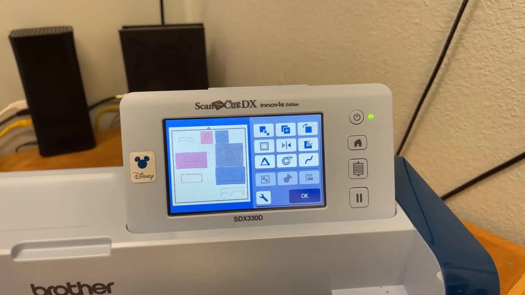 The ScanNCut SDX330D screen shows a scanned fabric mat background with digital cut outlines precisely aligned over multiple material scraps.