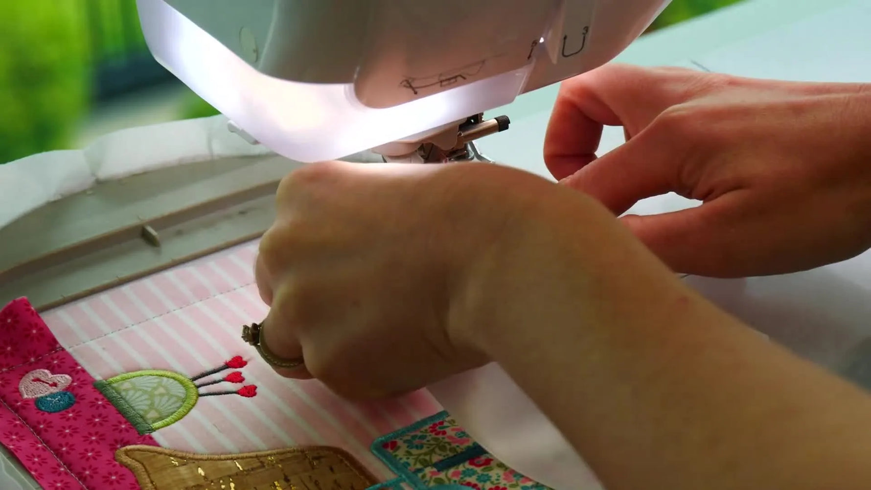 The completed two-panel “Love To Sew” wall hanger is shown finished and assembled, with the panels connected by tied white ribbons.