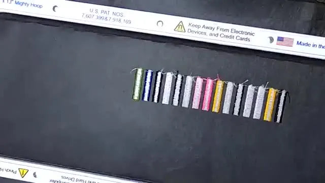 A close-up of the hoop’s back side showing 15 satin columns with different bobbin-thread ratios for tension comparison.