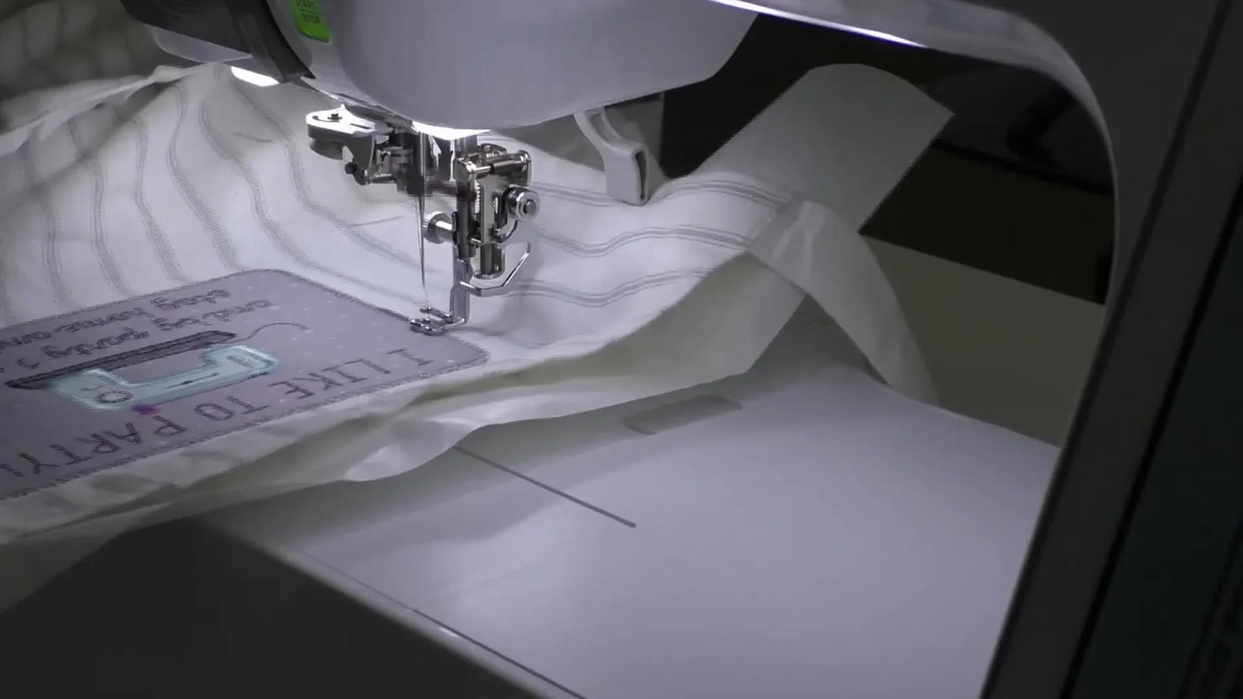 A close-up of the embroidery machine completing the final satin stitch border that gives the Kimberbell apron design a clean patch-style finish.