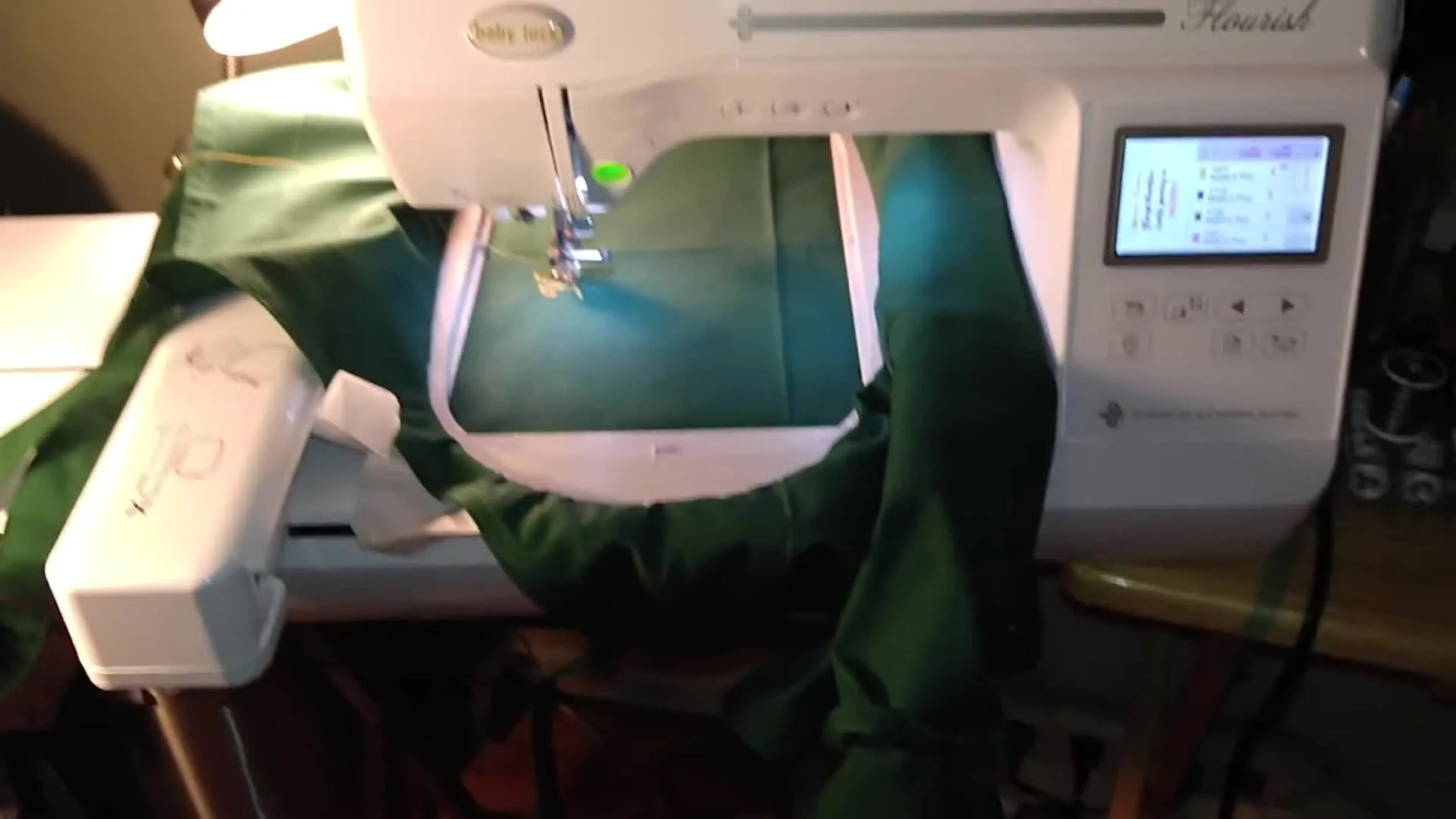 A Baby Lock Flourish embroidery machine sits ready with green fabric hooped, showing the real-world setup a beginner starts with.