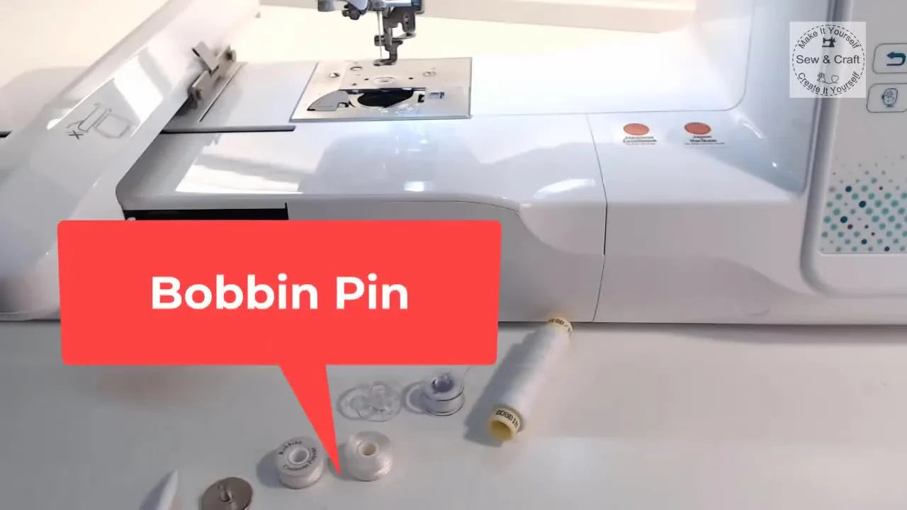 A close-up of the metal bobbin pin on the table, shown as the key spacer that stabilizes pre-wound bobbins in a domestic drop-in bobbin case.