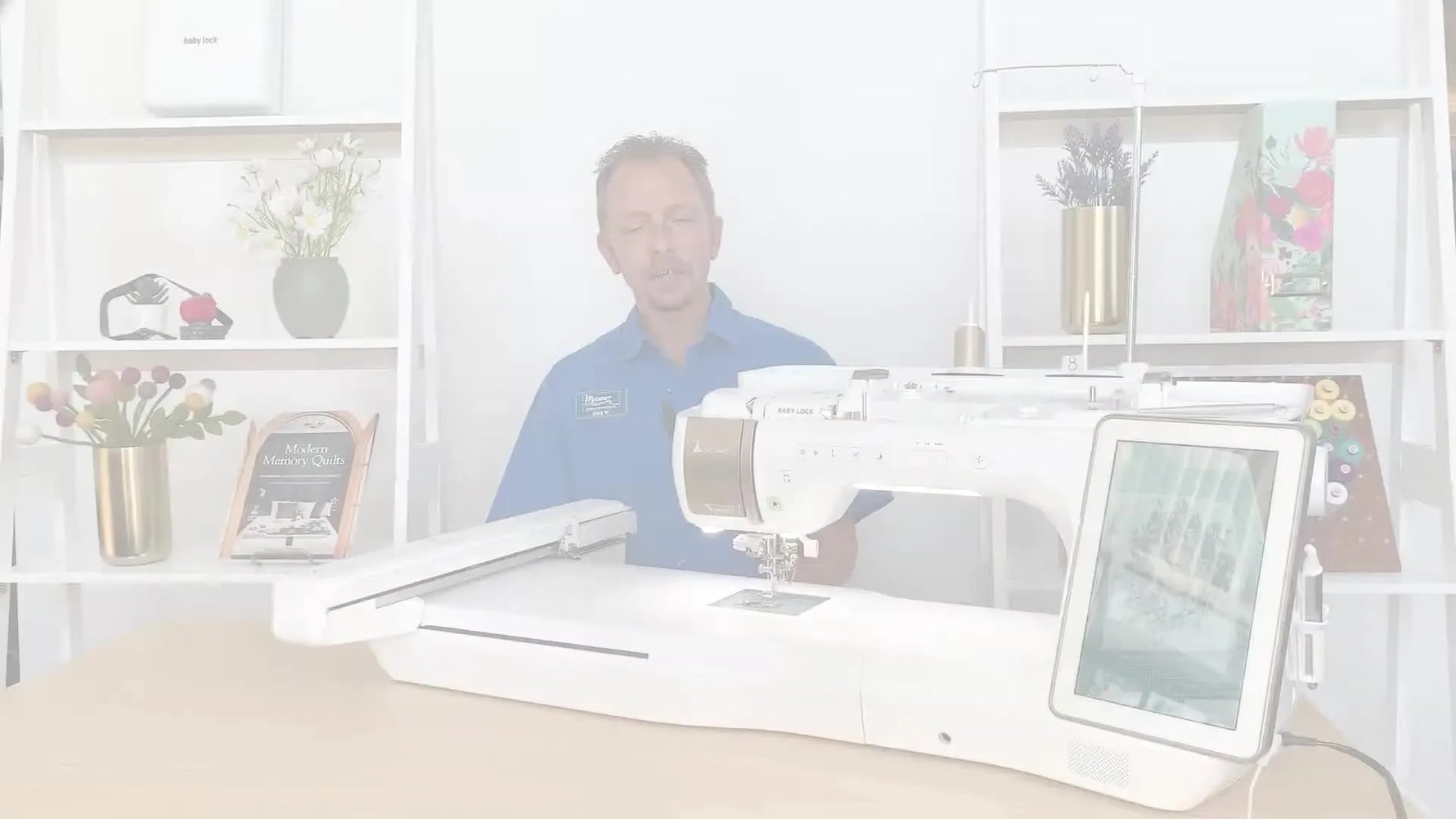A wide shot of the presenter standing beside the Baby Lock Solaris Vision, setting the stage for a sewing and embroidery feature demo.