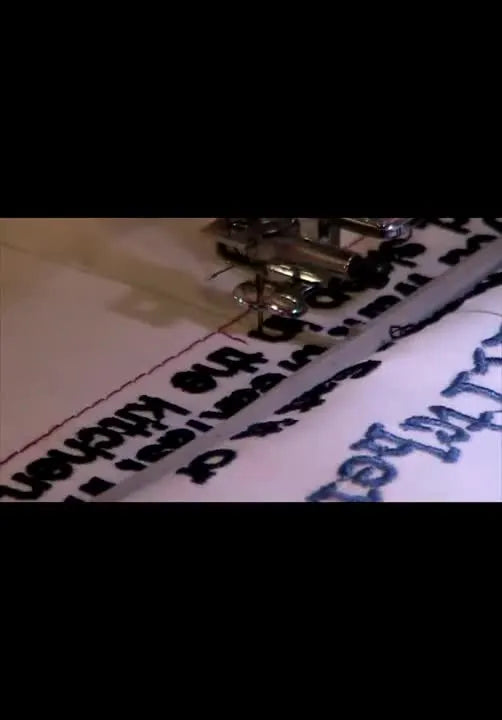 An extreme close-up of the needle being dropped onto a red reference line to confirm perfect alignment before stitching the next split section.