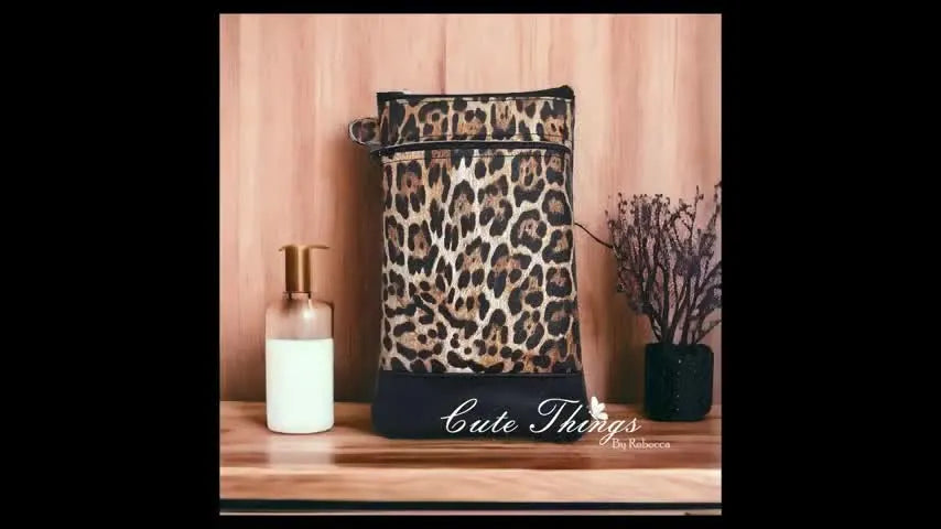 A finished double-zip leopard vinyl ITH bag standing upright with a crisp accent bottom and clean zipper openings.